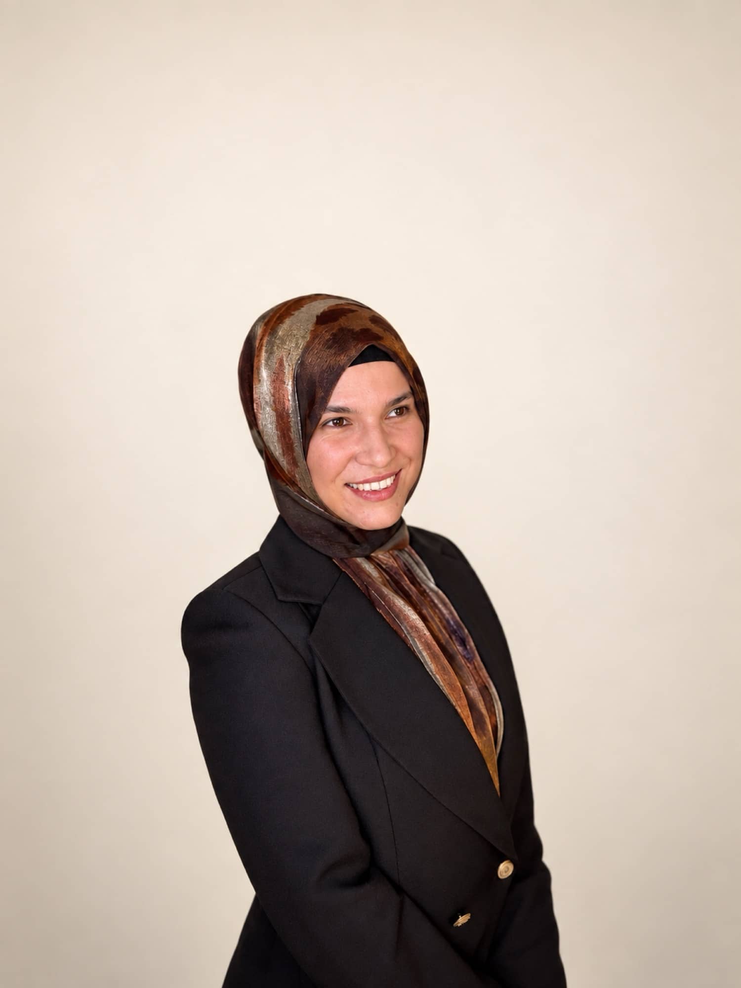 Hatice Emrem, krem fonda gülümserken